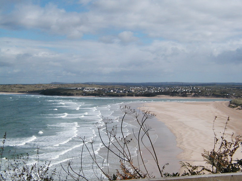 View down to large expanse of deserted beach, small waves rolling in