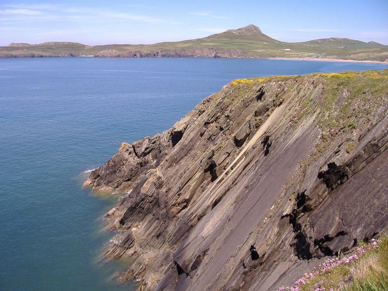 Smooth slabs topped by grass and gorse, angling down to the sea